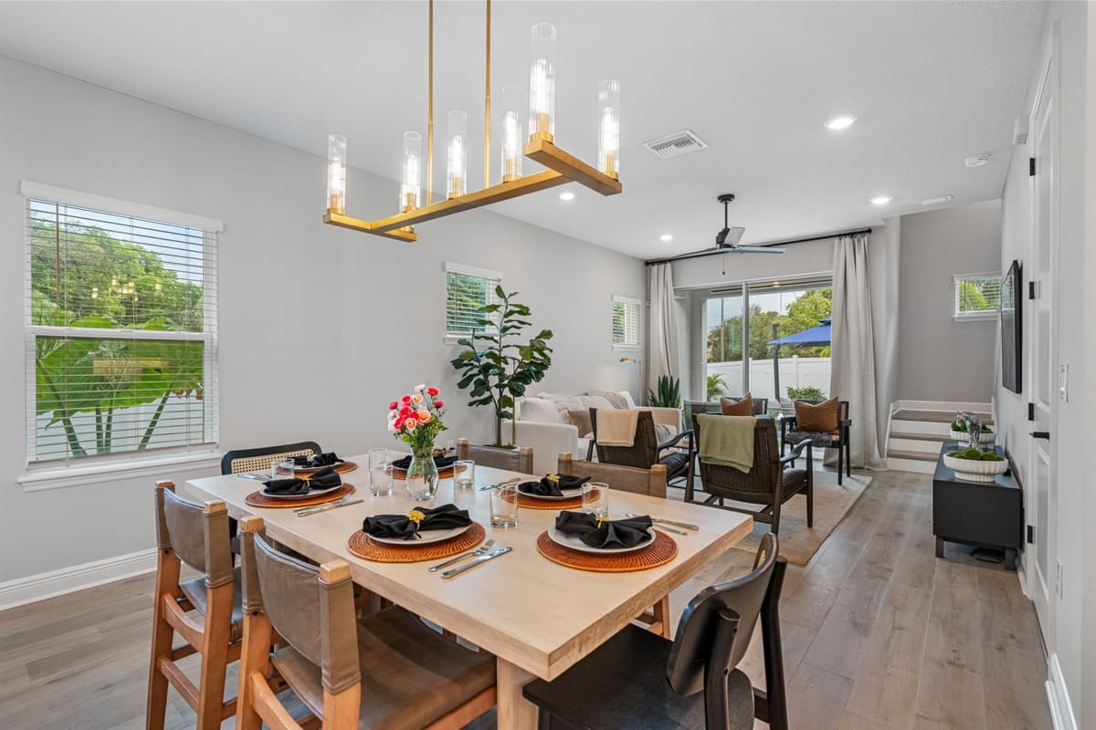 The dining area features a spacious table set for six, its rich wood finish and elegant design lending a touch of timeless charm to the room.