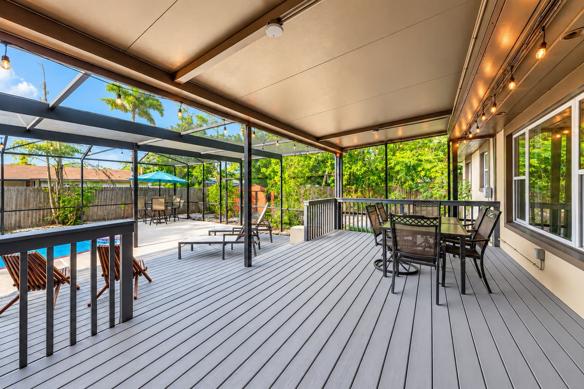 Beautiful screened patio with outdoor dining, pool views, and cozy evening lighting.
