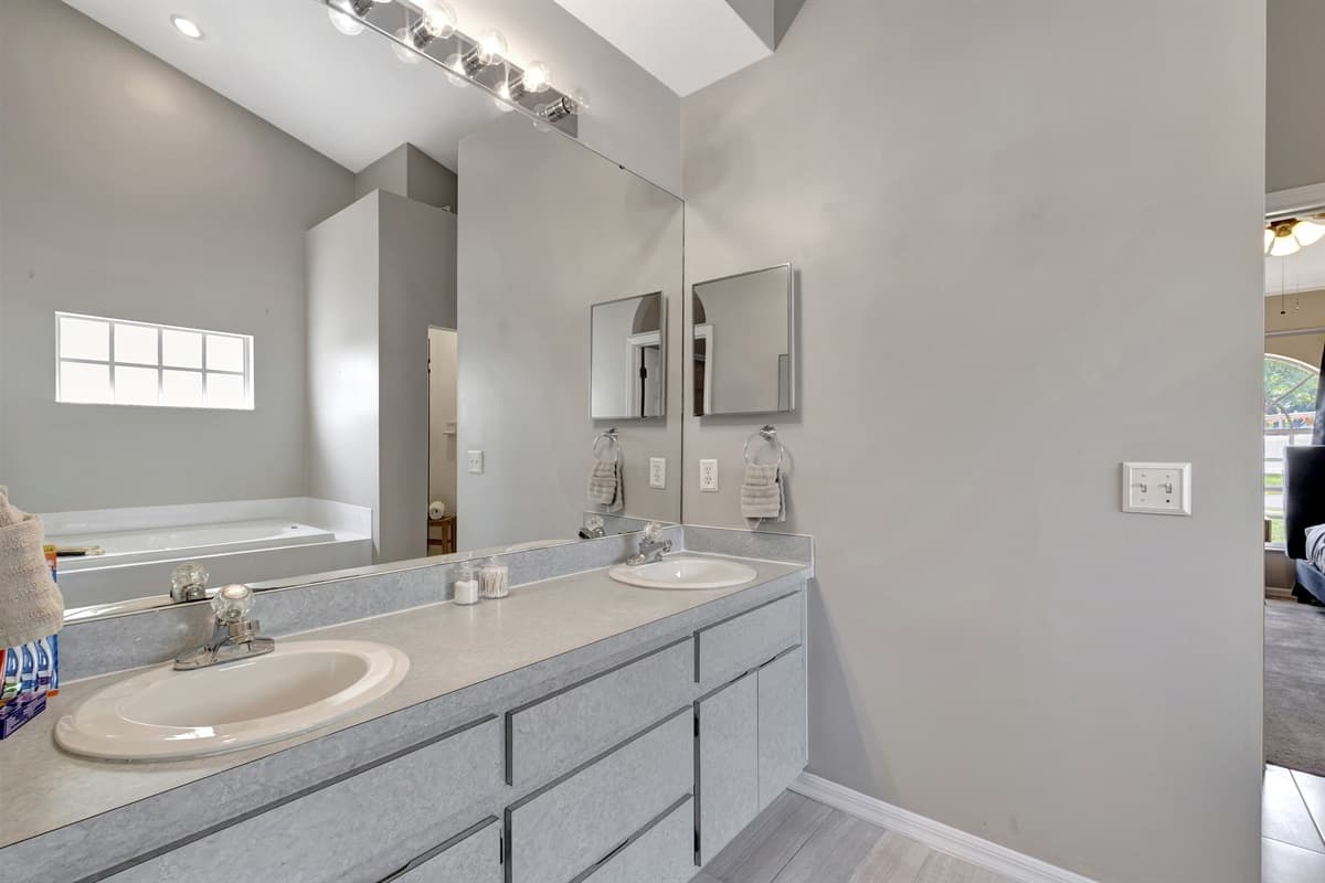 Dual his and her sinks grace the beautiful vanity, offering ample space for your personal belongings and ensuring a harmonious morning routine