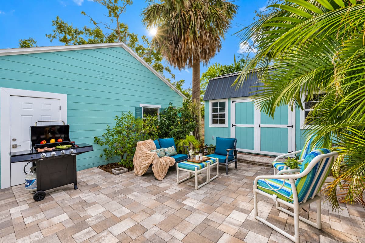 Relax in this inviting outdoor seating area surrounded by lush tropical landscaping and vibrant greenery.