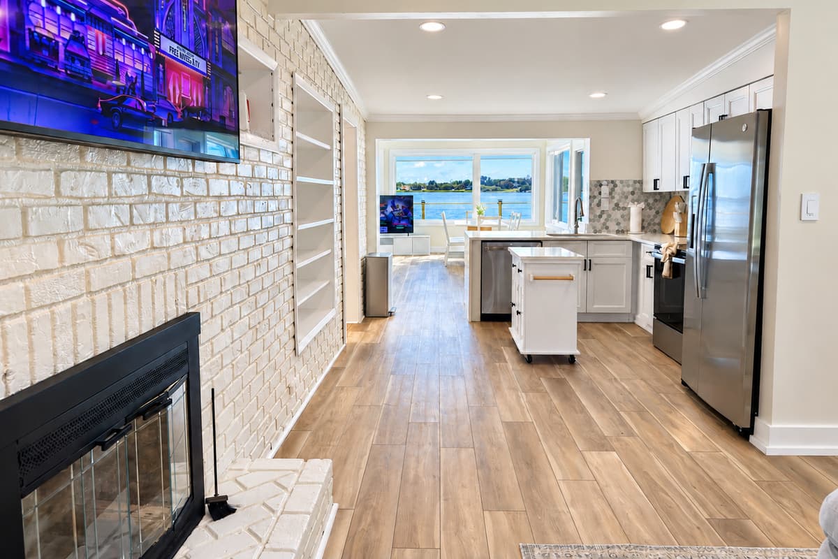 Front living room with sectional seating, TV and fireplace feature.