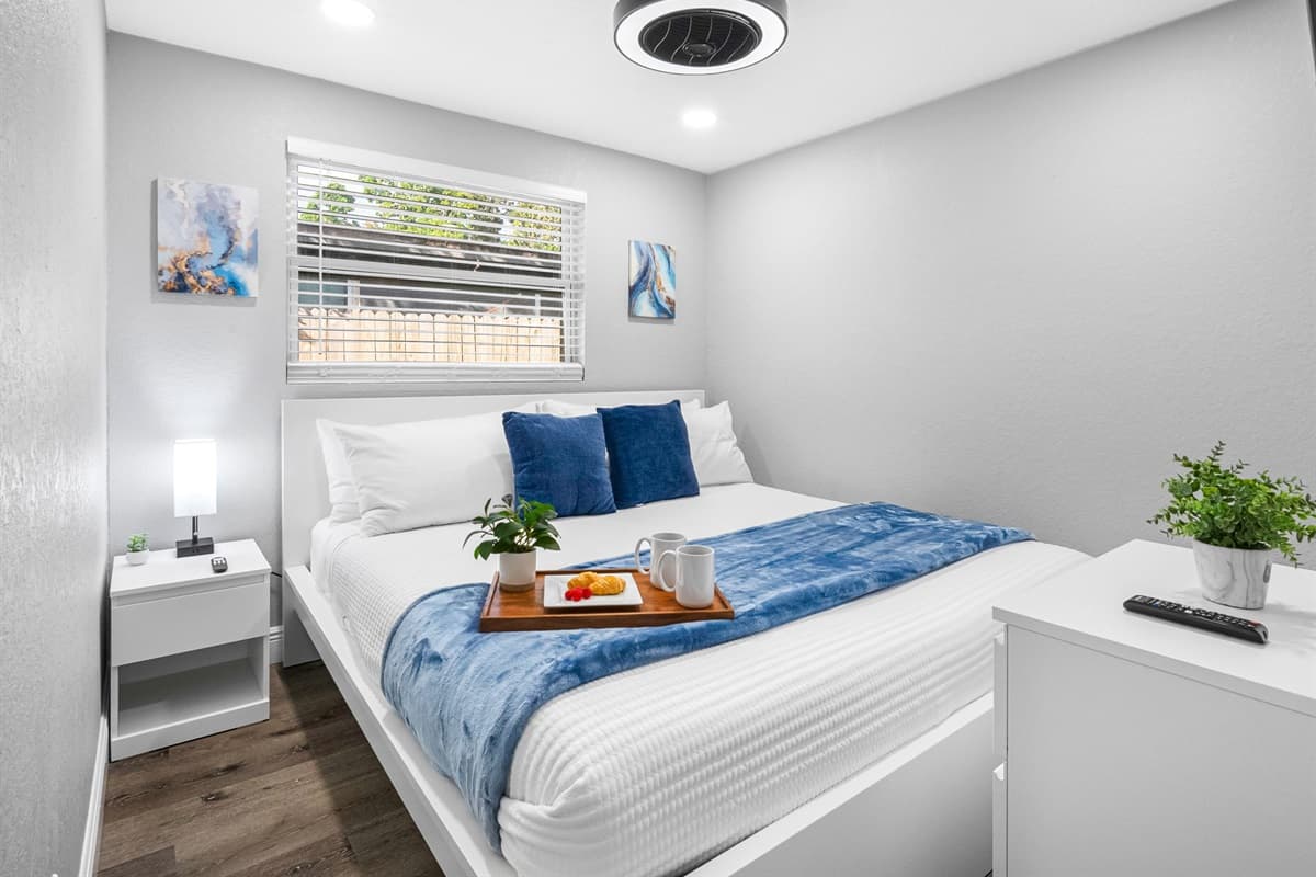 This serene bedroom invites you to rest easy with soft lighting, minimalist décor, and cozy bedding.