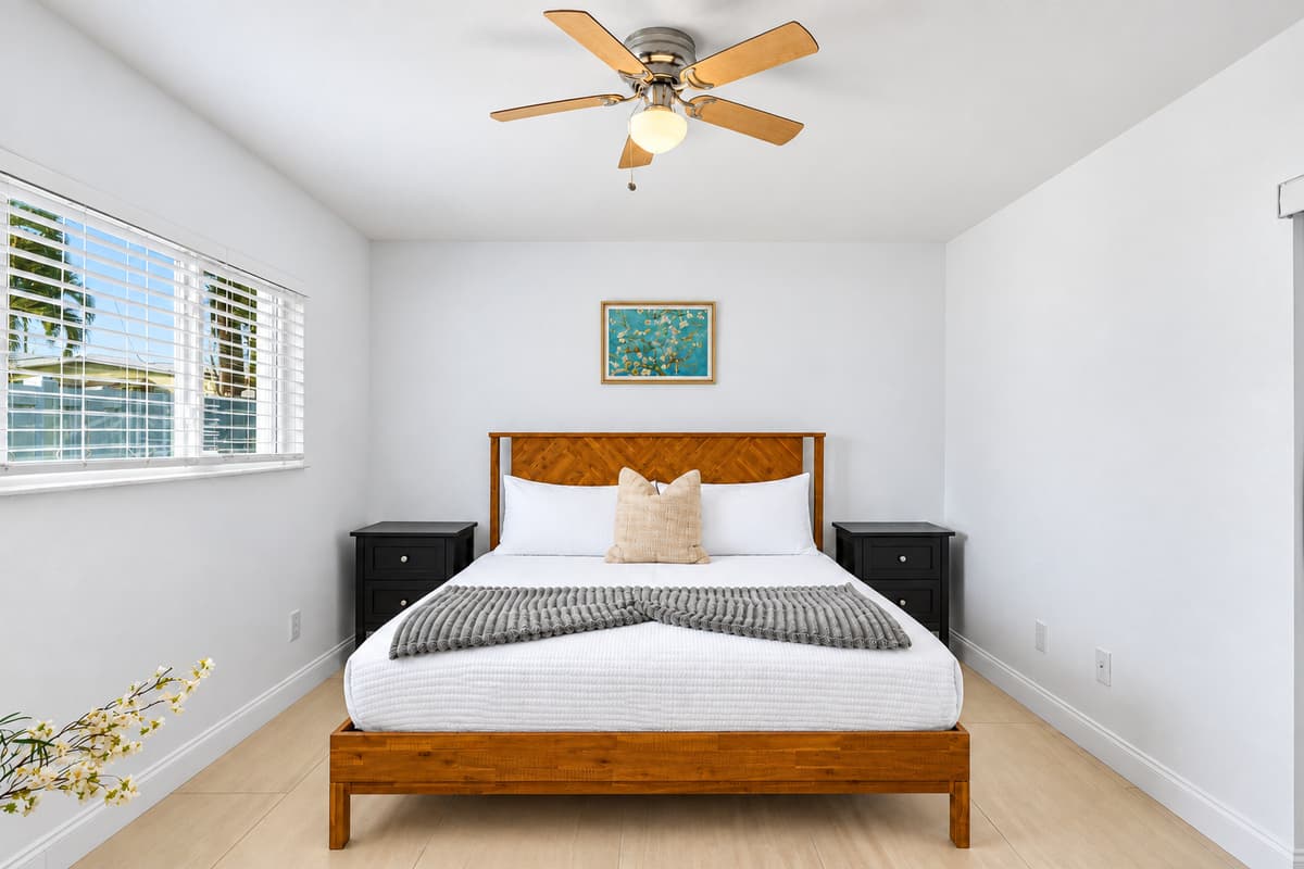 Bright and airy bedroom featuring a cozy wooden bed frame, modern décor, and natural lighting.