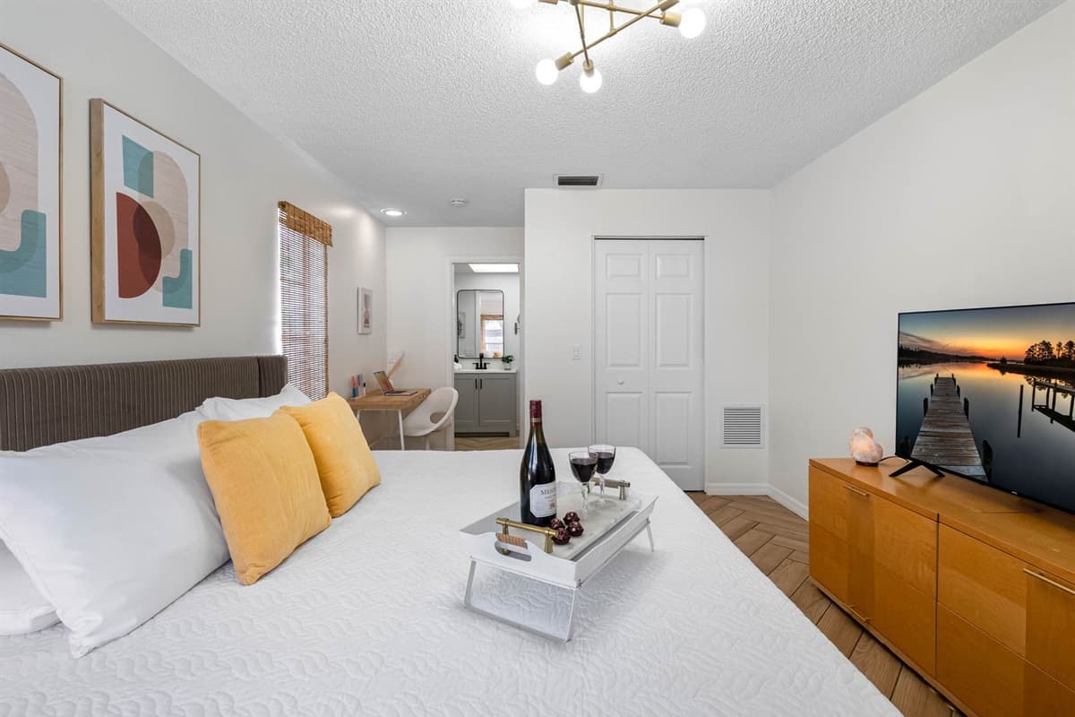 This bright and thoughtfully decorated suite features a king-size bed with ultra-soft linens, a flat-screen TV, and a modern vanity desk—your personal haven after a day exploring Tampa.