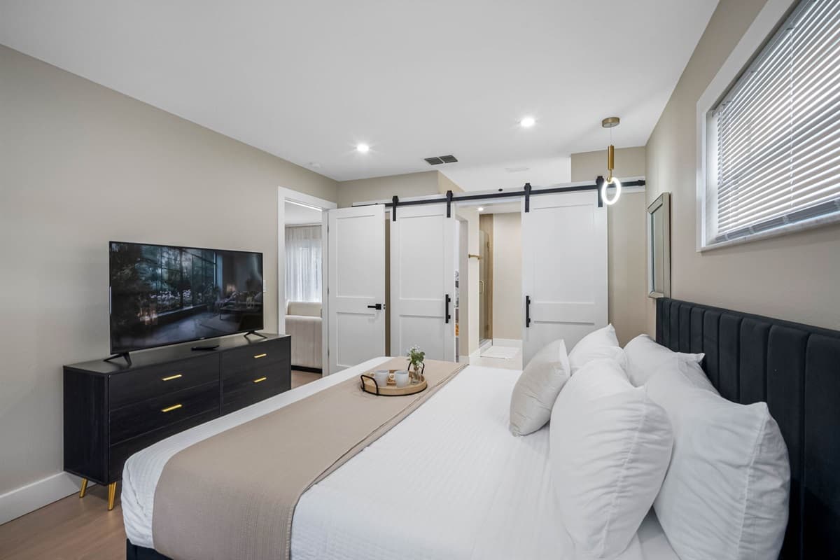 Unwind in this bright, modern bedroom with sleek furnishings and soft linens for a peaceful night’s sleep.