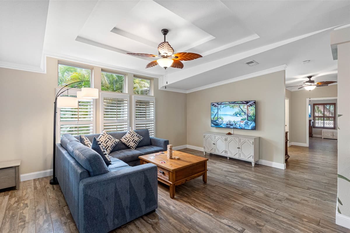 This coastal-inspired living space offers comfort and style, complete with warm natural light, a spacious sectional, and a hand-painted mural that brings the room to life.