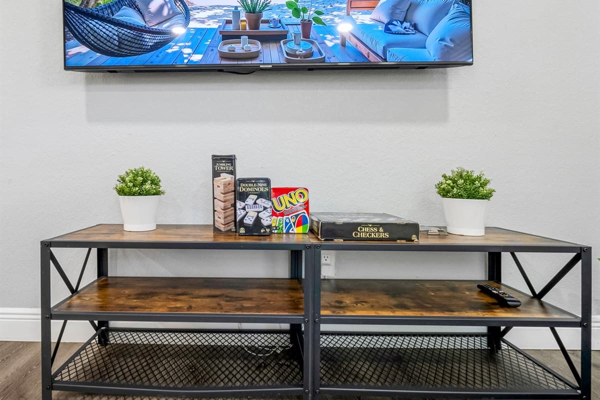 Enjoy movie nights or game time in this stylish setup complete with a flat-screen TV, indoor plants, and classic board games.