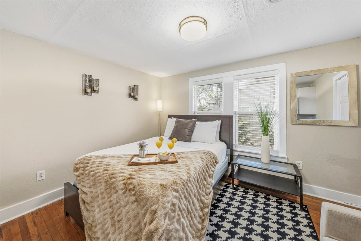 Charming bedroom featuring cozy bedding and a relaxing, homey feel.