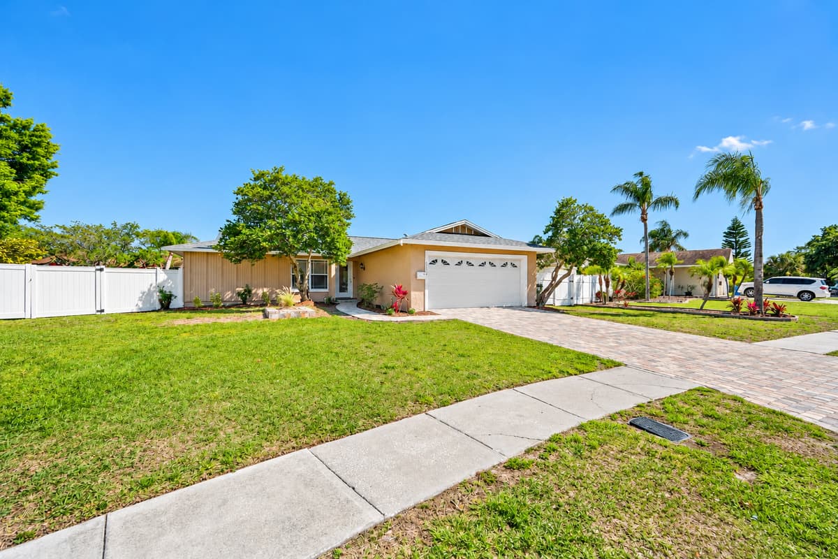 The beautiful side perspective of the house has a wide driveway and a garage. Who doesn't love a view of green grass and beautiful trees around the house? If you like what you see, send us a message as soon as possible!