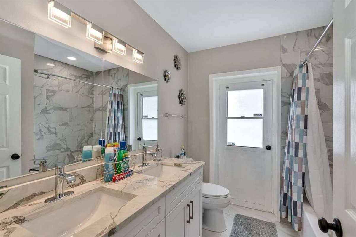 Beautiful bathroom equipped with his and hers sink, toilet, and shower. Enjoy a relaxing bath after a long day of travel from your home to your home away from home. If you think this property is for you, send us an inquiry right away!