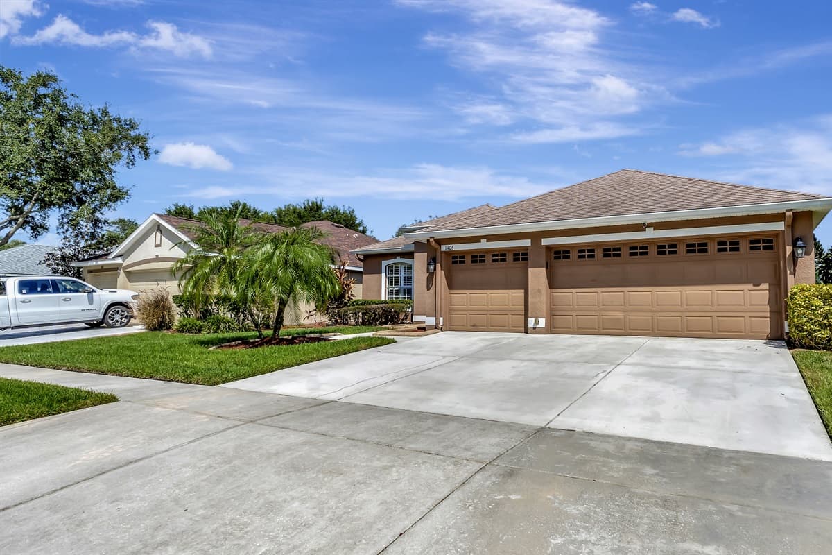 The exterior of this stunning home boasts a lush green front lawn and an exceptionally spacious driveway.