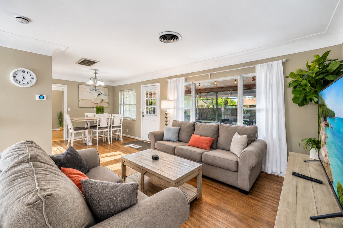 Spacious open-concept living area featuring comfortable sofas, large windows, and plenty of natural light.