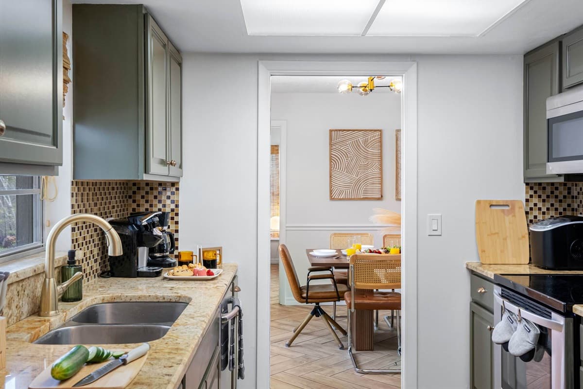 Fully equipped with modern appliances and charming green cabinetry, this kitchen makes cooking at home a breeze—from quick breakfasts to full family dinners.