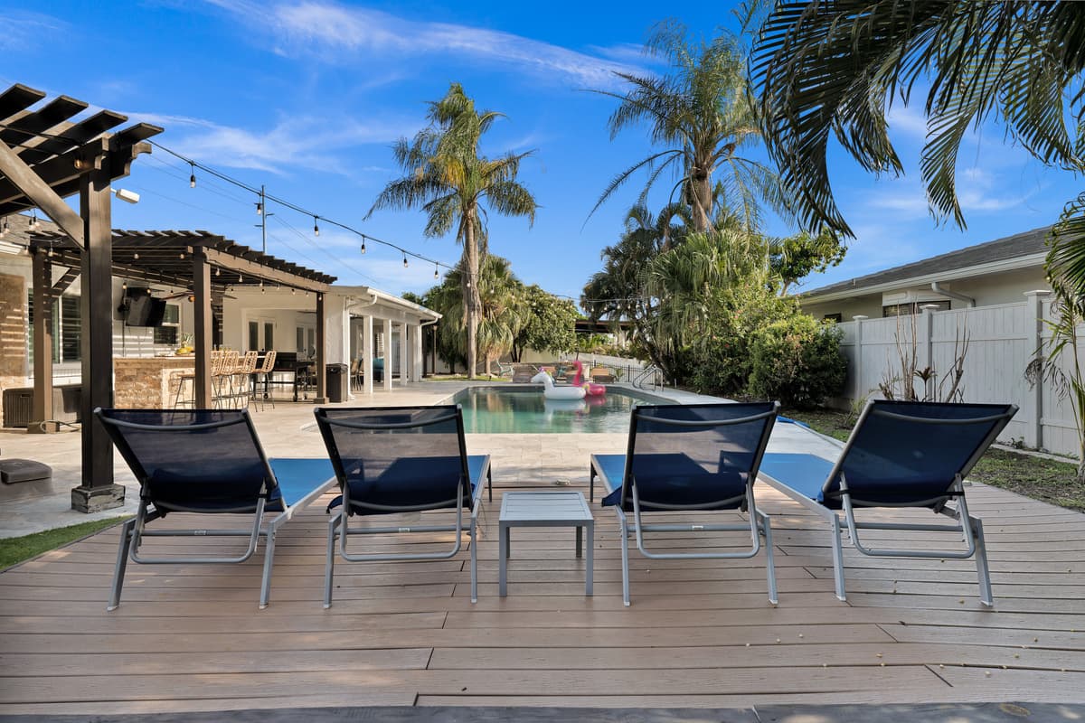 Blue loungers wait under the pergola, shaded and ready for an afternoon of poolside reading