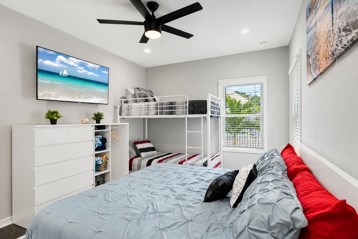 Elegant bedroom with king sized bed, single bunkbed, , drawers for storage and smart TV. Ideal room for a group of friends or a family with kids.