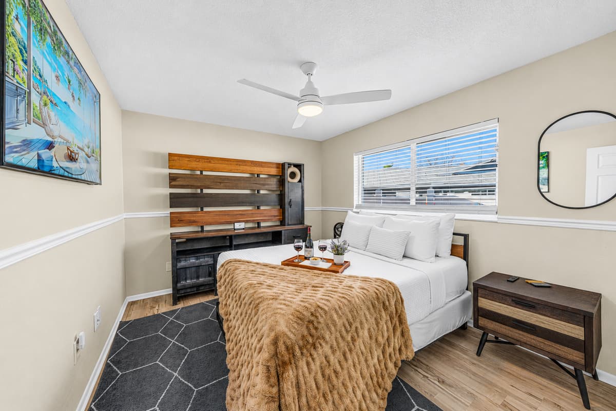Stylish queen bedroom with modern furnishings, Smart TV, and a comfortable night's sleep.