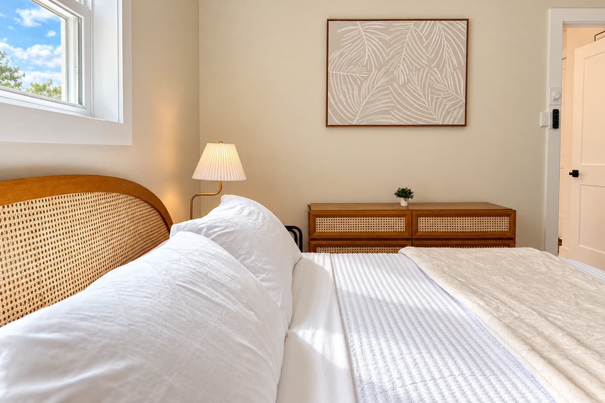 King bedroom with a woven wood headboard and coastal decor.