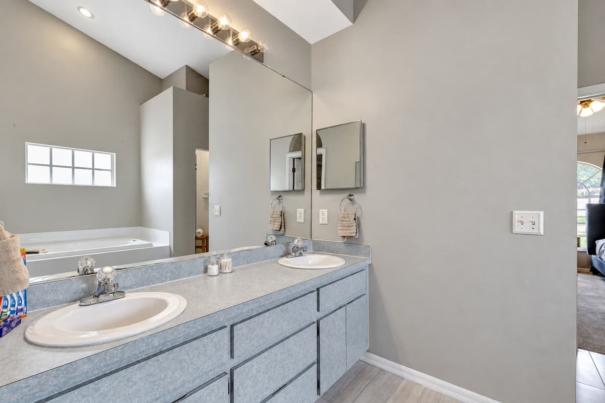 Dual his and her sinks grace the beautiful vanity, offering ample space for your personal belongings and ensuring a harmonious morning routine