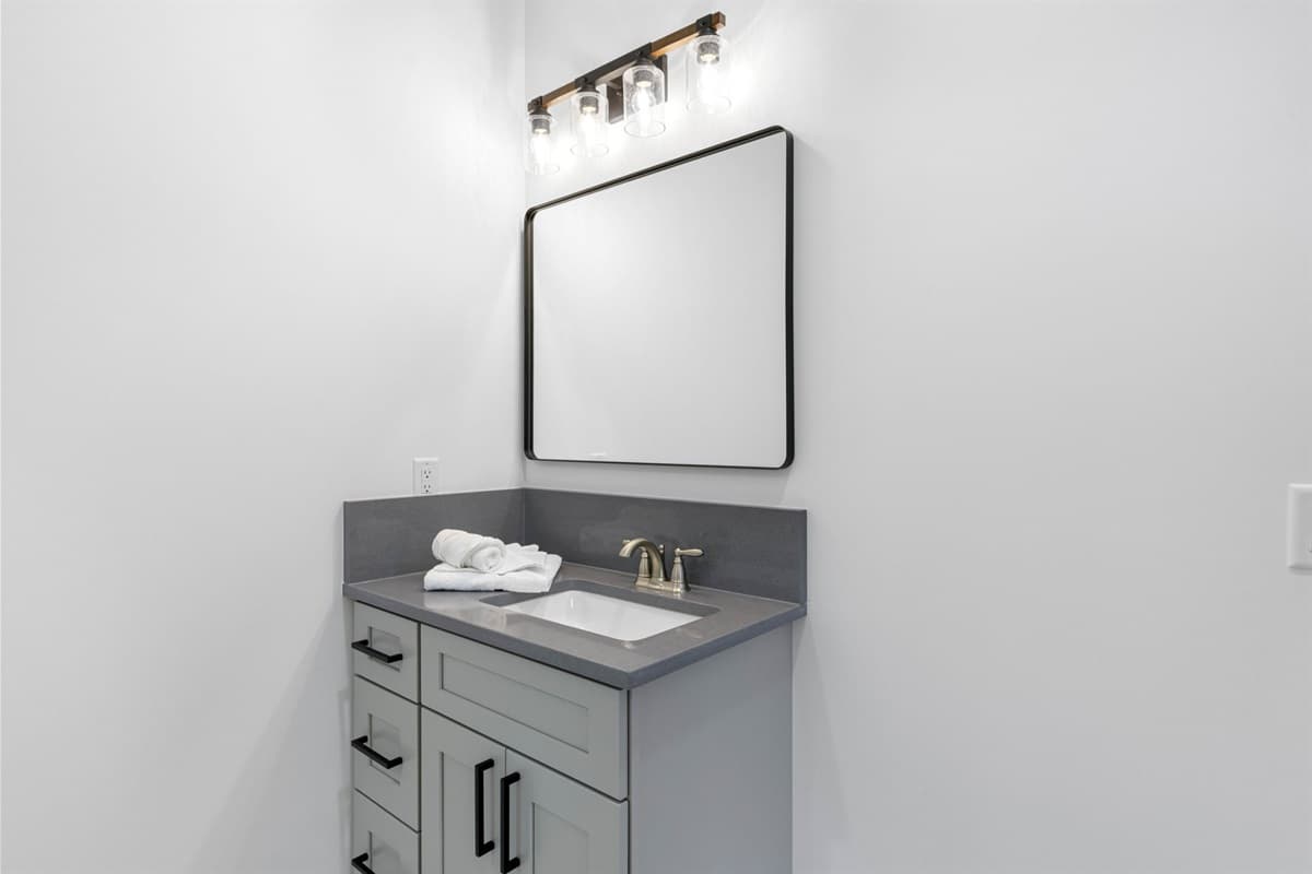 The elegant fixtures throughout the space, including a modern sink, showerhead, and faucets, provide a sleek and sophisticated look.