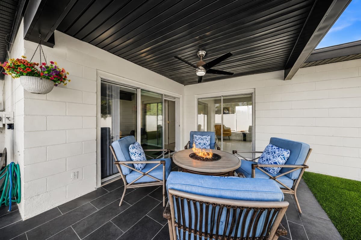 Inviting outdoor entertainment space with fire table, lounge seating, and patio access.