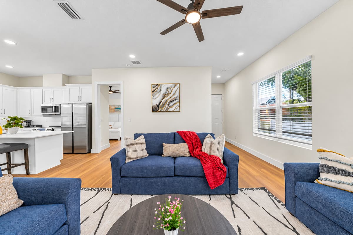 Bright living area with large windows and seamless flow into the fully equipped kitchen.