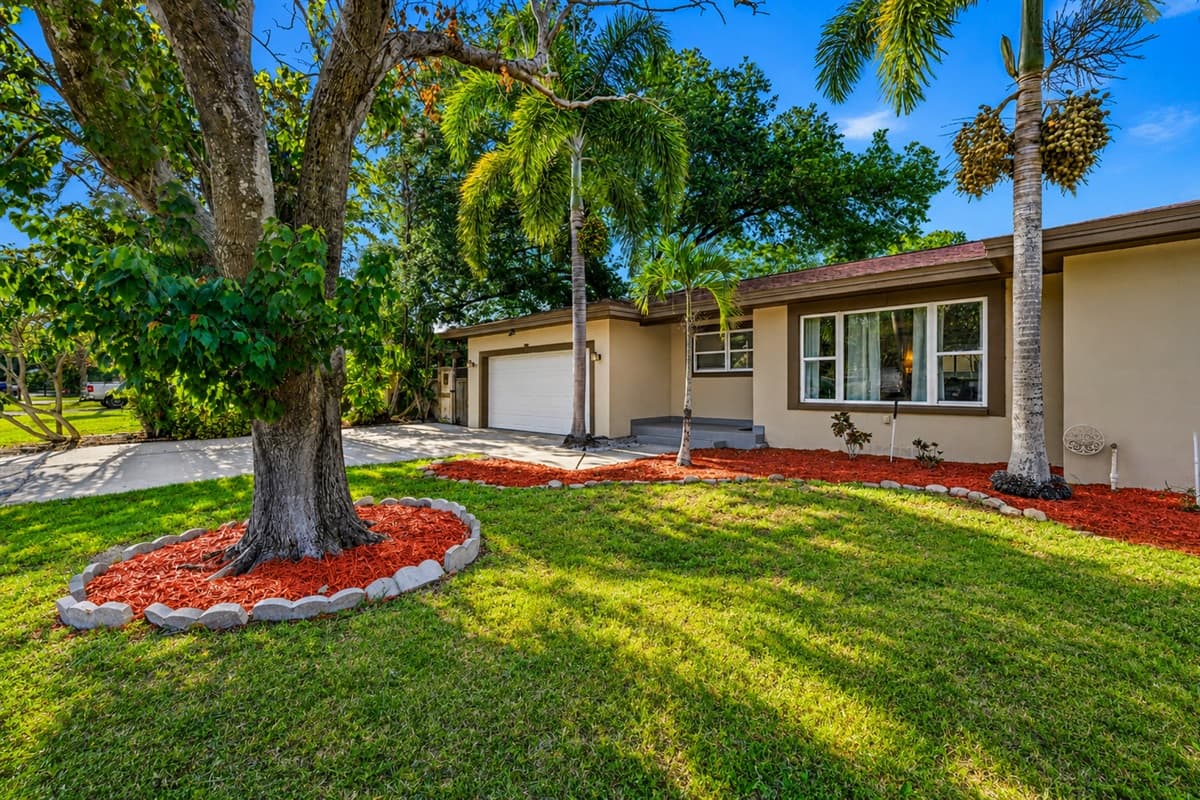 Charming front yard with mature trees, manicured lawn, and inviting curb appeal.