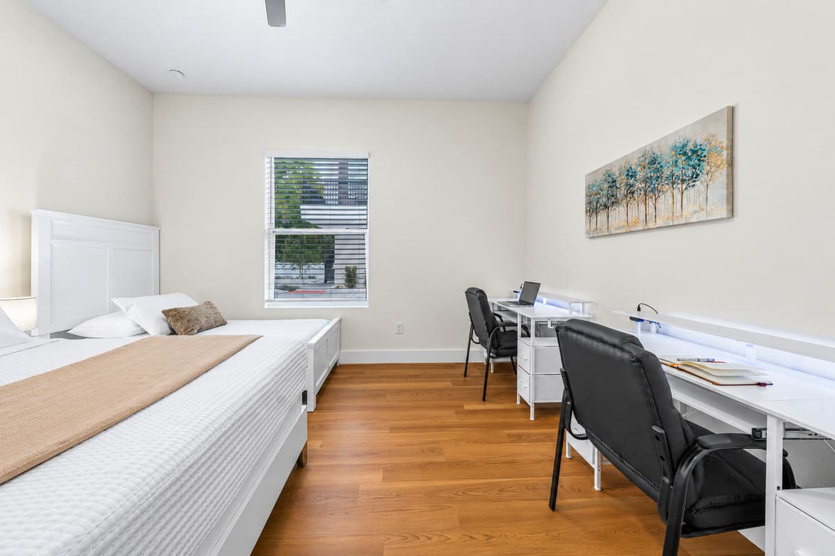 The second bedroom doubles as a home office — a comfortable bed plus a workspace with a view.