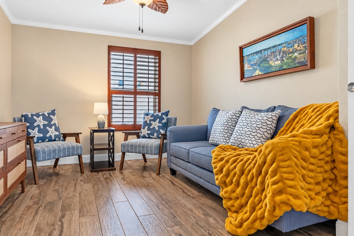 This cozy bedroom features a stylish pullout sofa bed, offering a comfortable sleeping option with flexible use during the day. Coastal décor, warm wood floors, and soft lighting create a relaxing and inviting retreat.