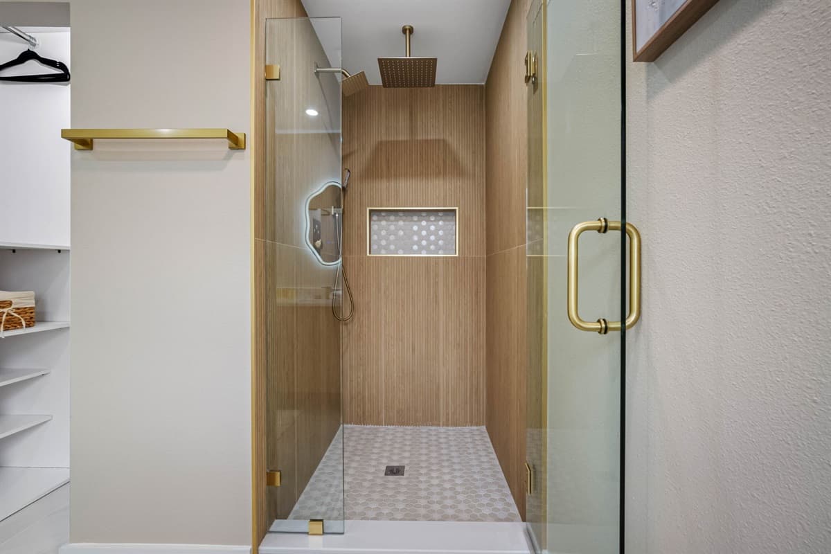 Featuring a sleek walk-in shower and contemporary double vanity, this bathroom combines beauty and practicality for a refreshing experience.