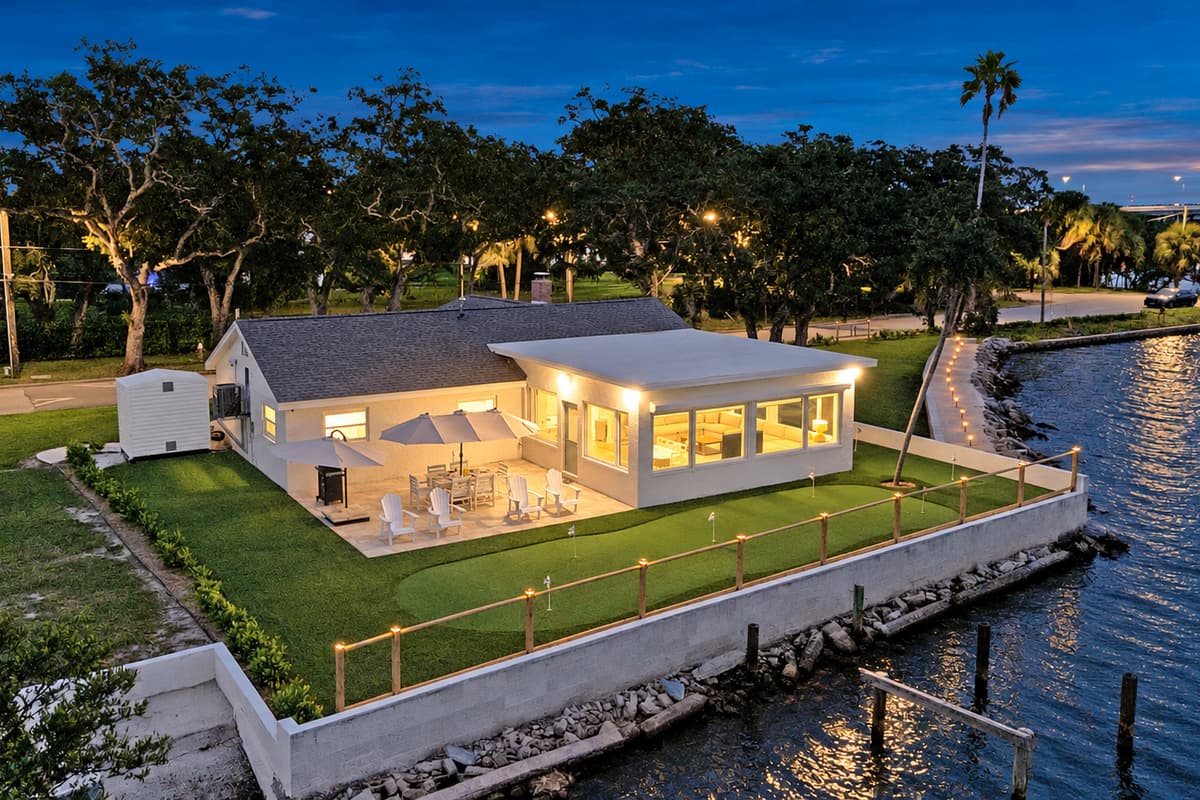 Waterfront living from above. The patio, putting green and seawall glow at dusk, with the bay wrapping around the property. A private corner of Tampa Bay all to yourselves.