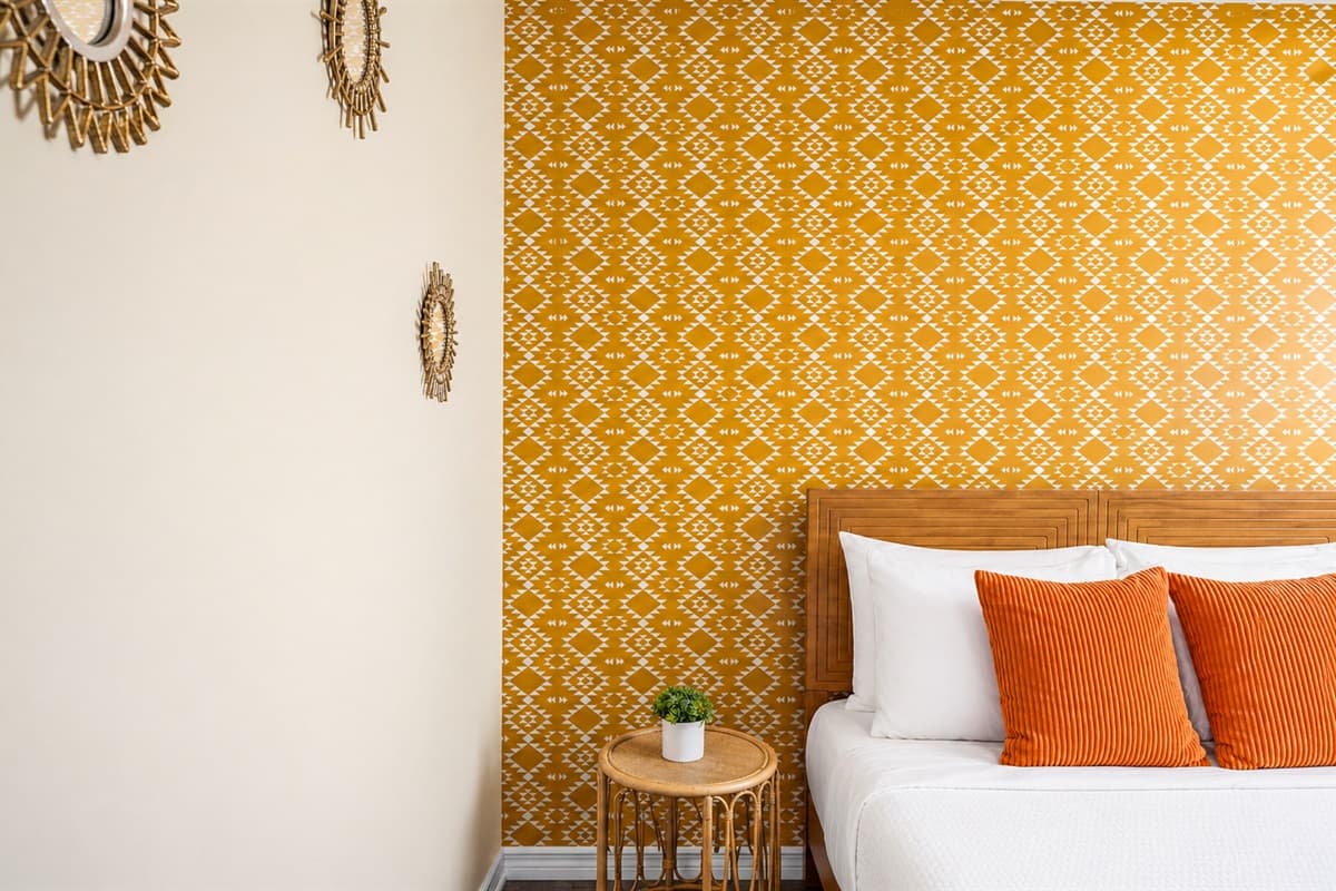 Close-up of the beautifully styled bed with bold accent wall and modern décor touches.
