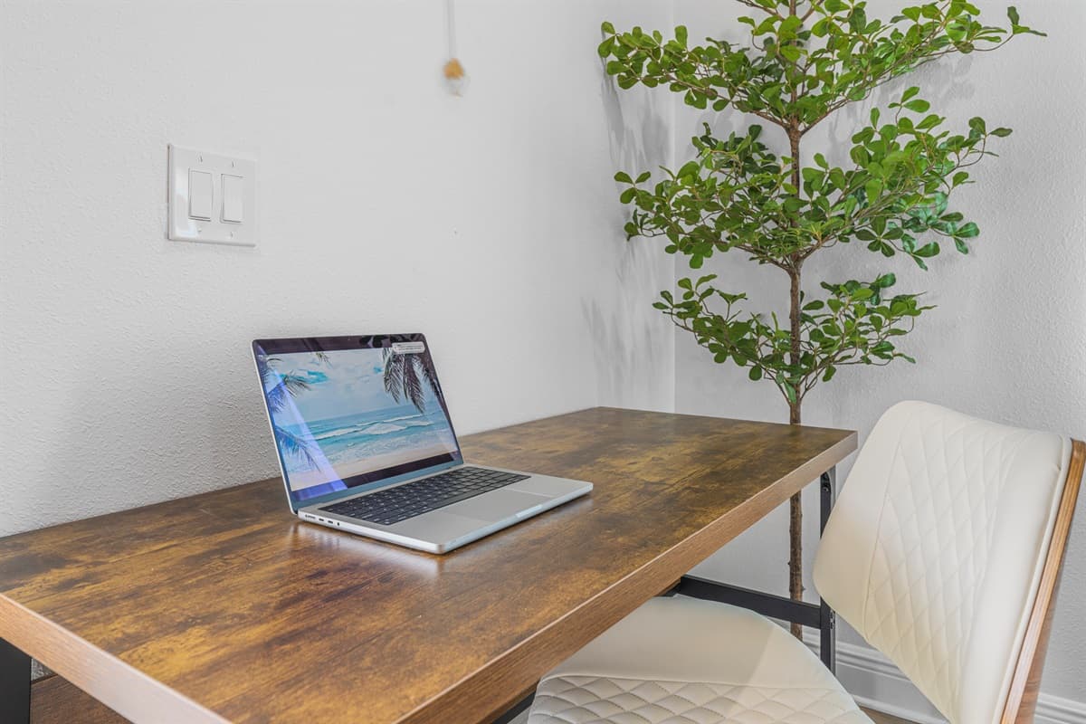 Close-up of the workspace desk with laptop and modern decor, offering a clean and functional work environment.