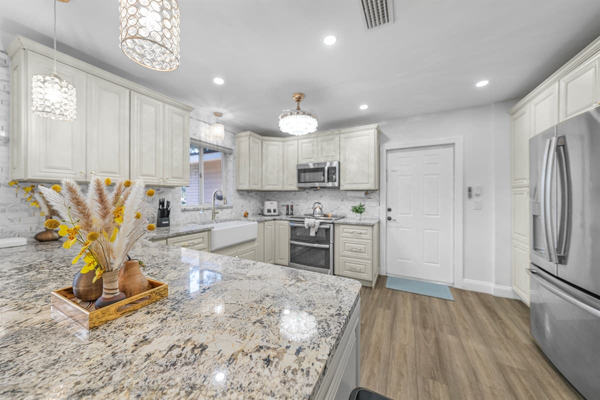 The kitchen is a true showpiece, highlighted by stunning countertops, custom cabinetry, and elegant lighting that elevates every meal.