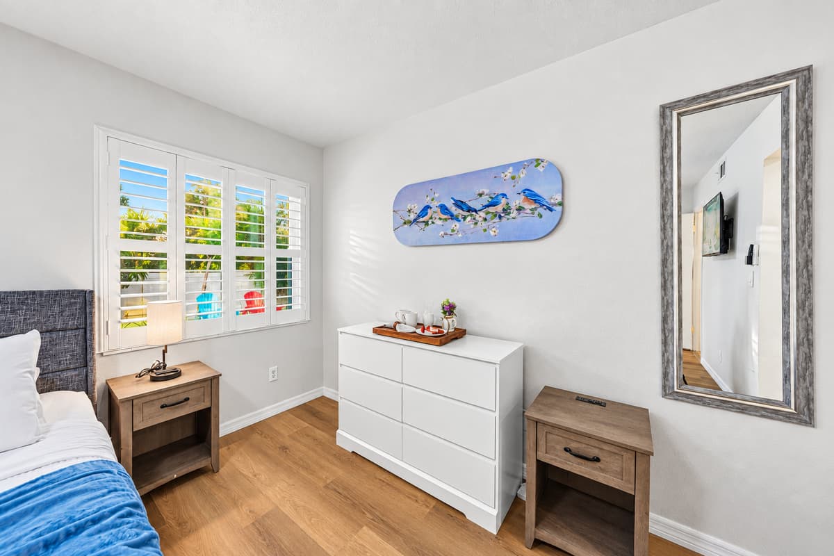 Well-lit bedroom with stylish furnishings, ample storage, and a relaxing, minimalist design 