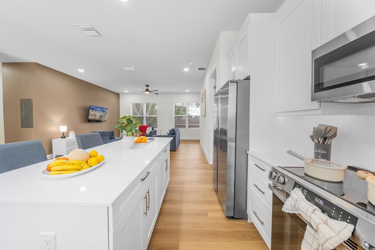 Sleek, fully equipped kitchen with stainless steel appliances, spacious island, and open views into the living area—ideal for cooking and entertaining.