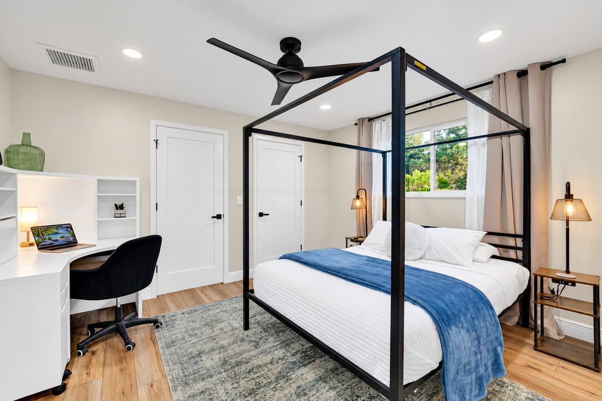 The suite you'll try to claim again next year. King canopy bed, warm bedside lamps and a workspace with a view of the trees — comfortable enough that leaving the room feels optional.