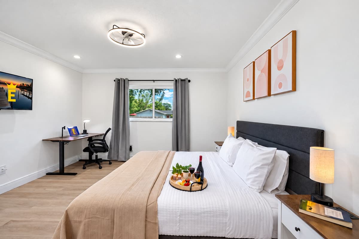 Stretch out on the plush king-size bed in this serene, hotel-inspired bedroom with fresh white linens and cozy lighting.