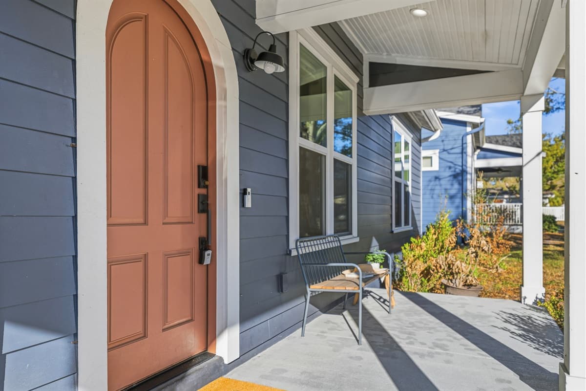 The covered front porch is your new favorite spot — featuring a chic metal bench, floor-to-ceiling windows, and that stunning arched terracotta door. Arrive in style every single time at this brand-new Seminole Heights retreat.