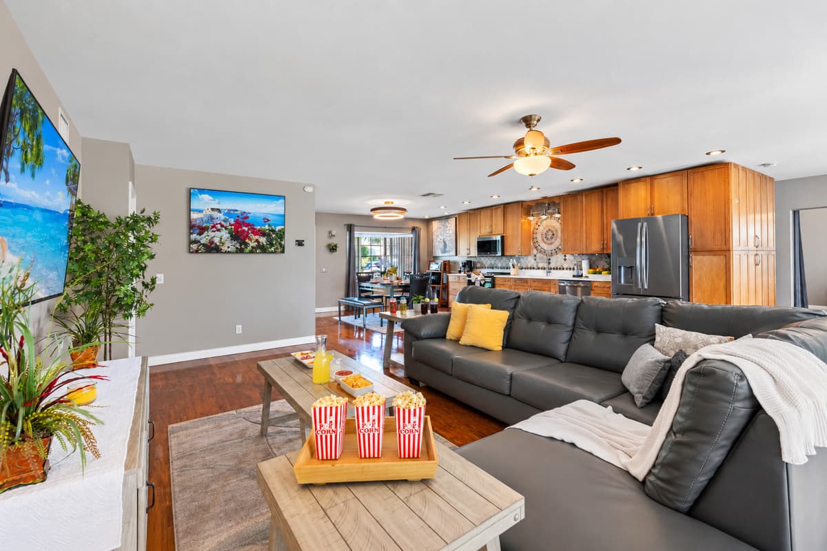 With a large TV setup, abundant seating, and easy access to the kitchen for snacks, this living room is the ultimate entertainment hub.