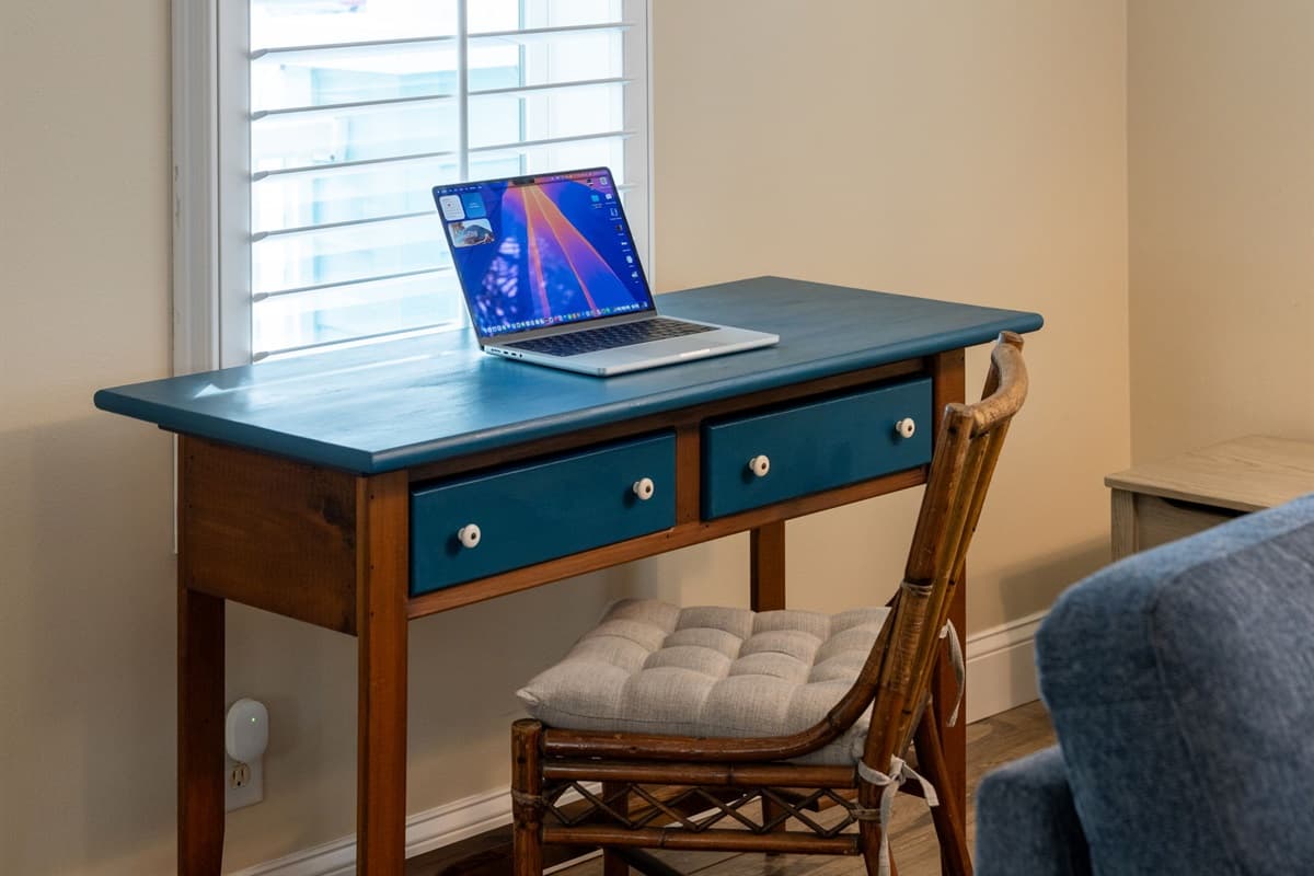 A cozy workspace is tucked into the living area, complete with a colorful desk, comfortable seating, and bright natural light—perfect for remote work, studying, or planning your adventures.