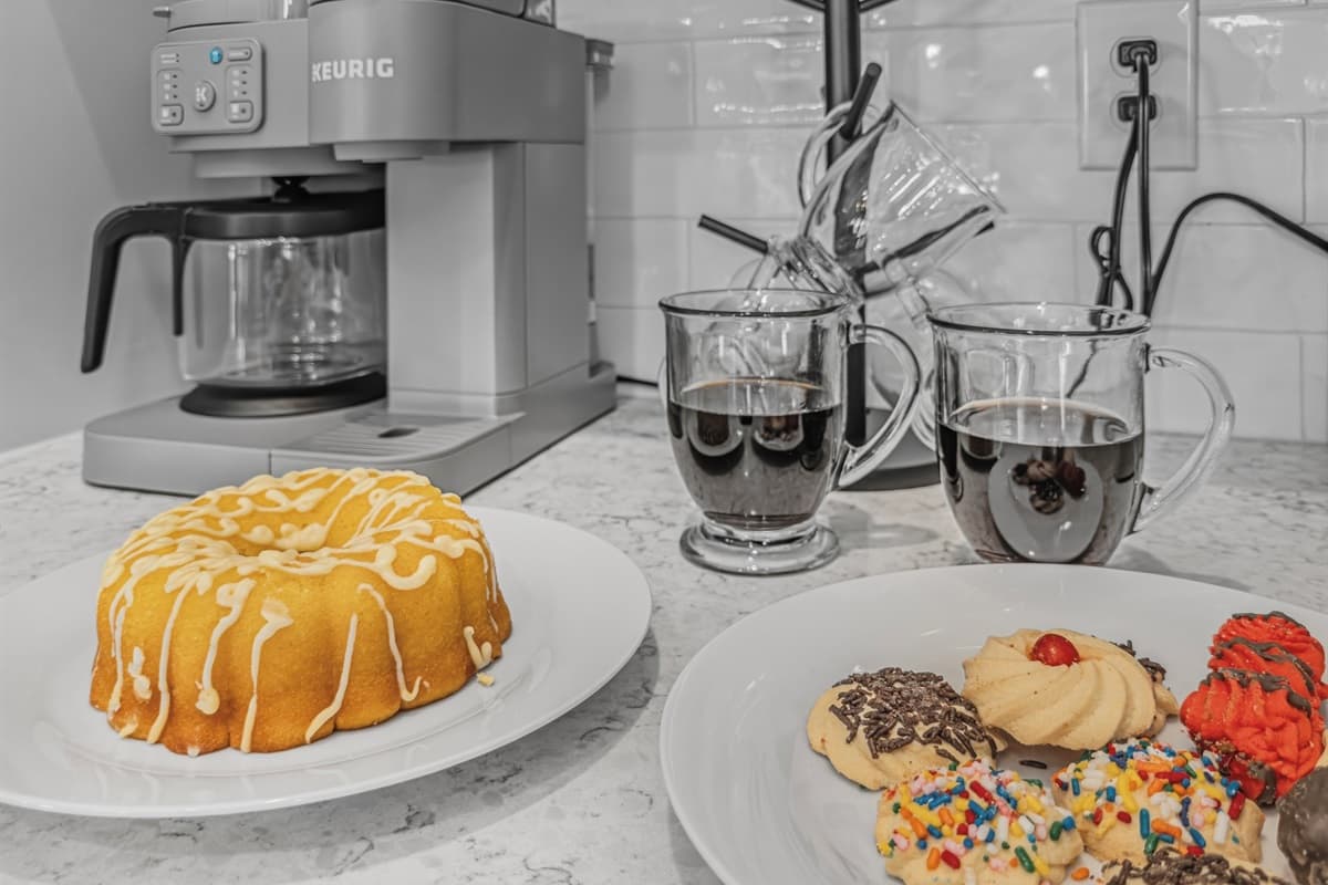 The kitchen is always ready — a drip coffee maker, glazed lemon pound cake, and colorful cookies await. This brand-new Seminole Heights home treats every guest to a little indulgence from the moment they arrive.