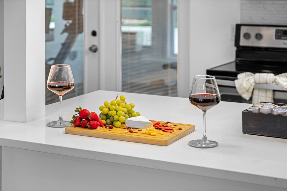 Kitchen counter with wine, fresh fruit, and a charcuterie spread.