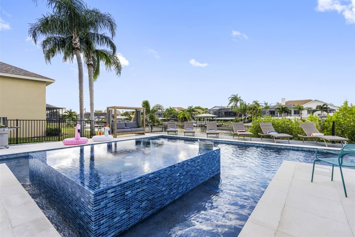 The pool and spa area is softly illuminated, creating a magical ambiance perfect for a night swim or gathering with loved ones.