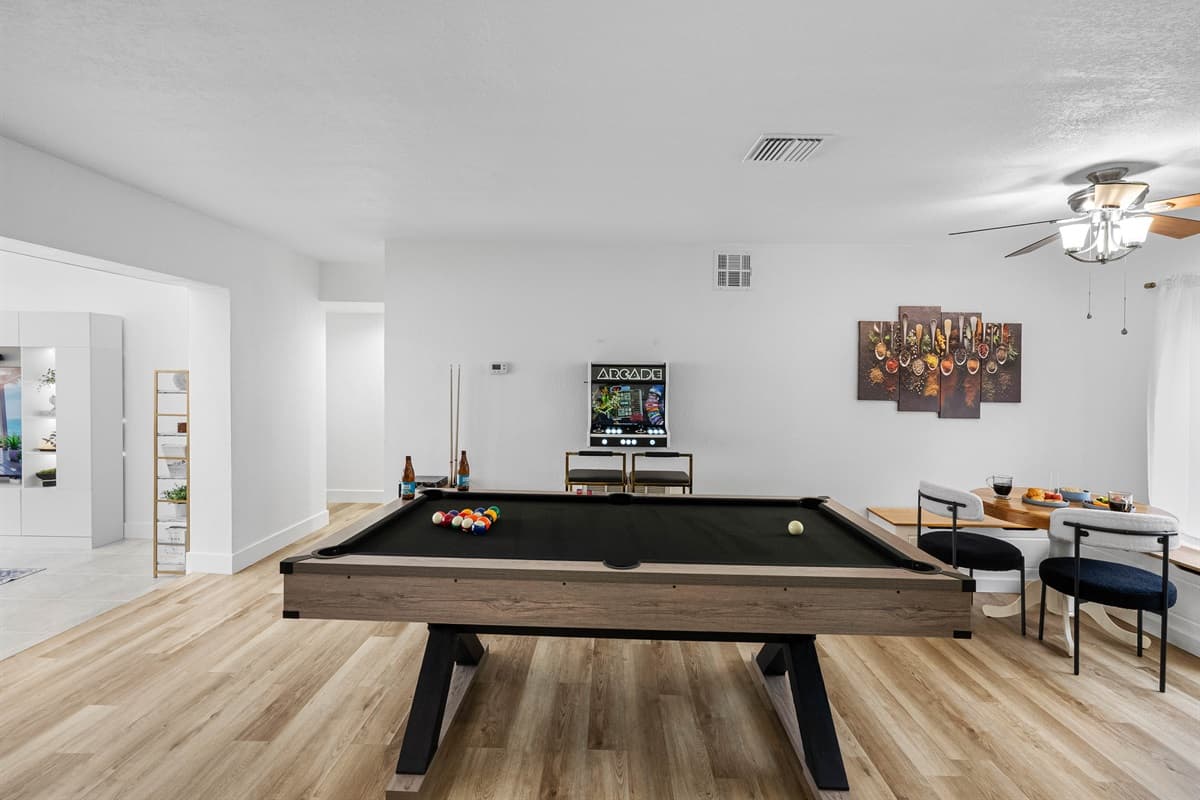 A perfect space for playful competition, this entertainment room features a sleek black pool table, foosball, and nostalgic arcade games.