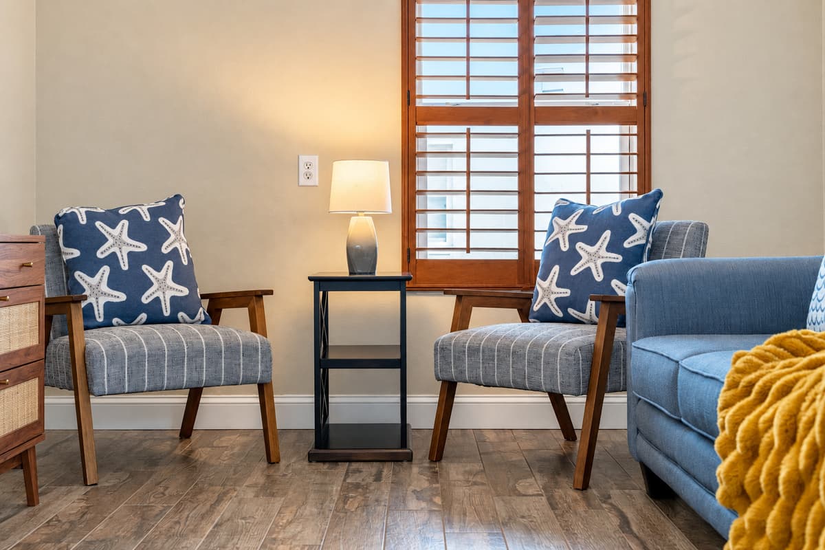 This charming guest bedroom offers a comfortable pullout sofa bed, blending function and style. Warm wood flooring, soft textiles, and natural light create a serene and restful atmosphere.