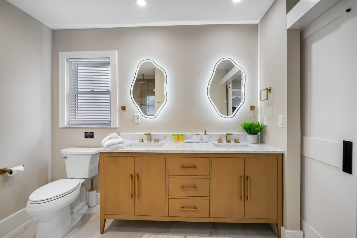 Enjoy the clean lines, warm wood cabinetry, and luxury finishes that make this bathroom a peaceful retreat for guests.