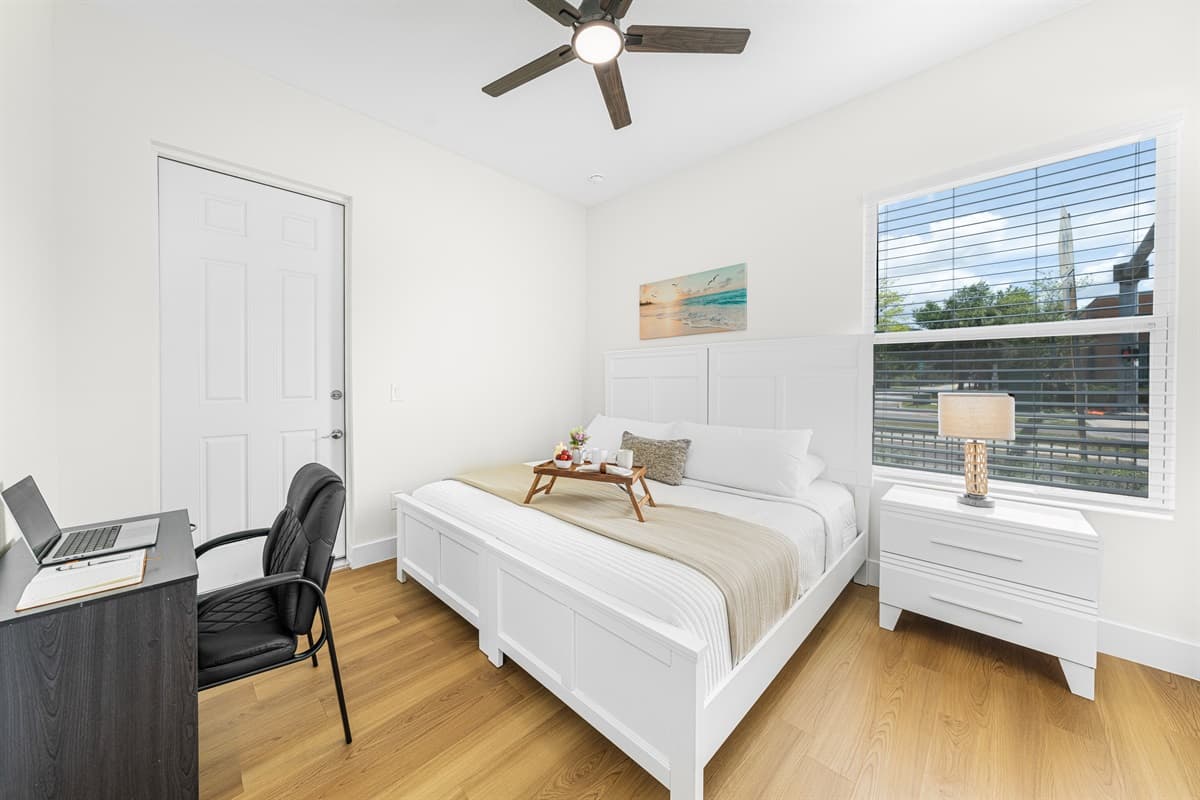Cozy bedroom with comfortable bed, workspace, and plenty of natural light.