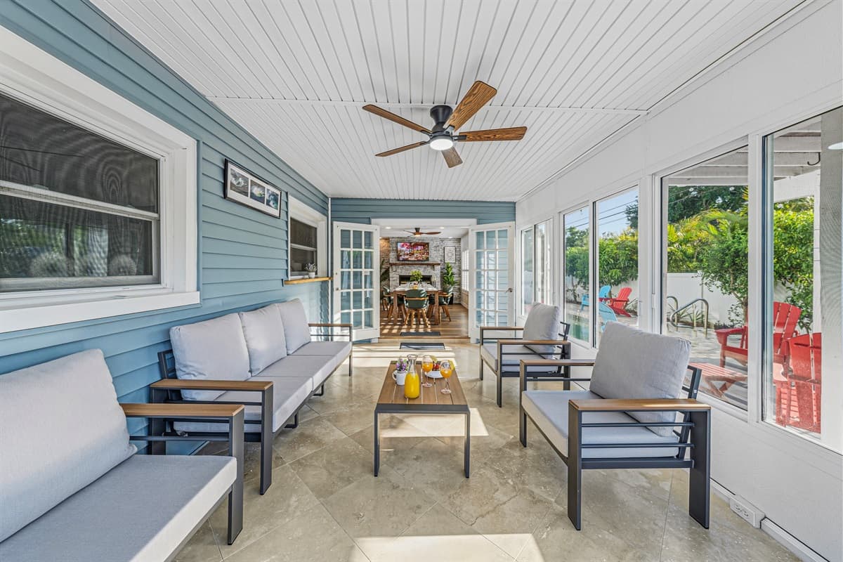 Spacious sunroom with multiple seating areas, perfect for relaxing or gathering with friends and family 