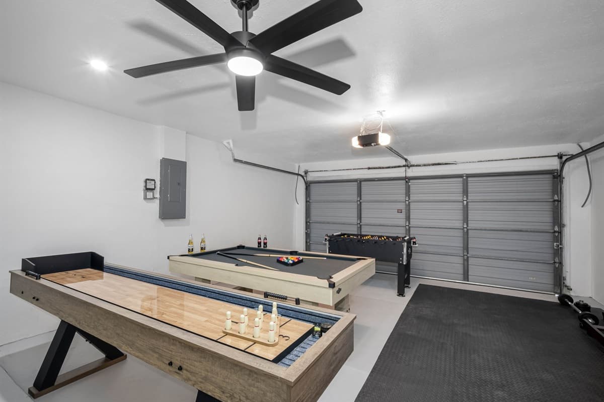 Endless entertainment awaits in this multipurpose game and fitness room featuring a pool table, foosball, shuffleboard, and workout equipment — fun for all ages!