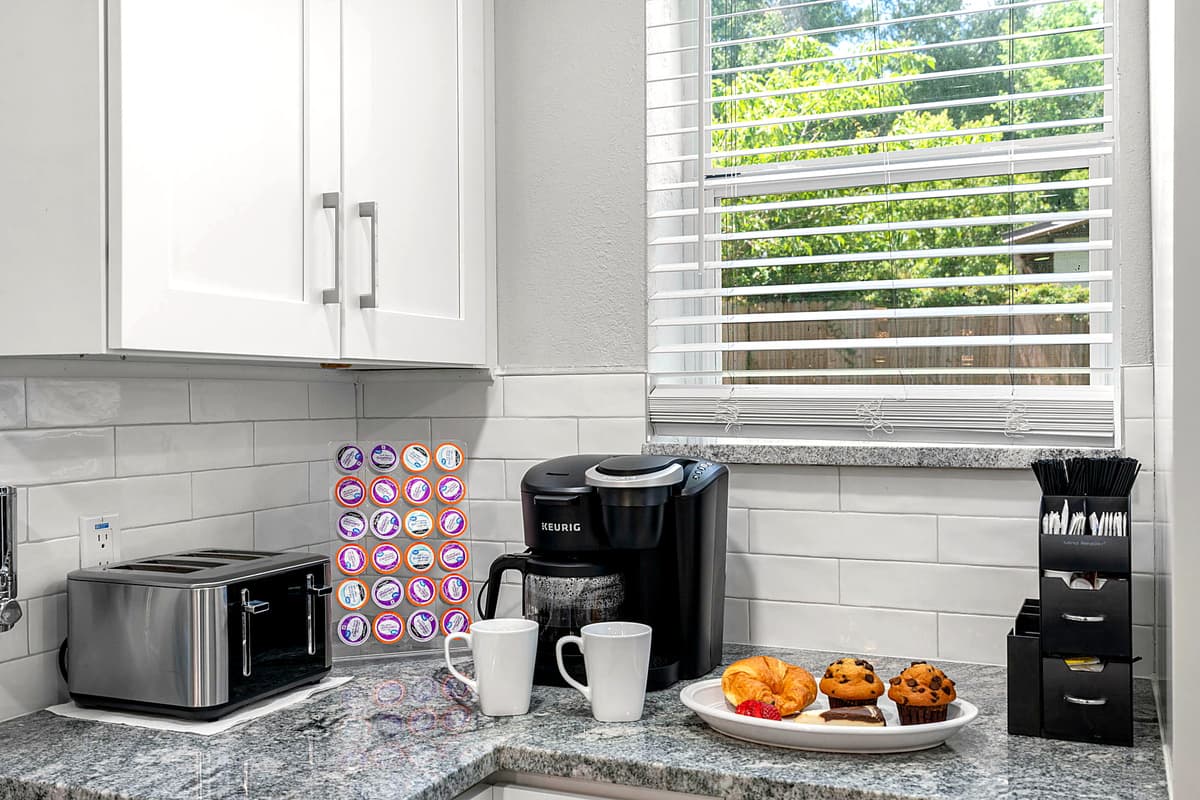 Accents such as a stylish backsplash, sleek hardware, and thoughtfully chosen decor items add the finishing touches to this exquisite kitchen.